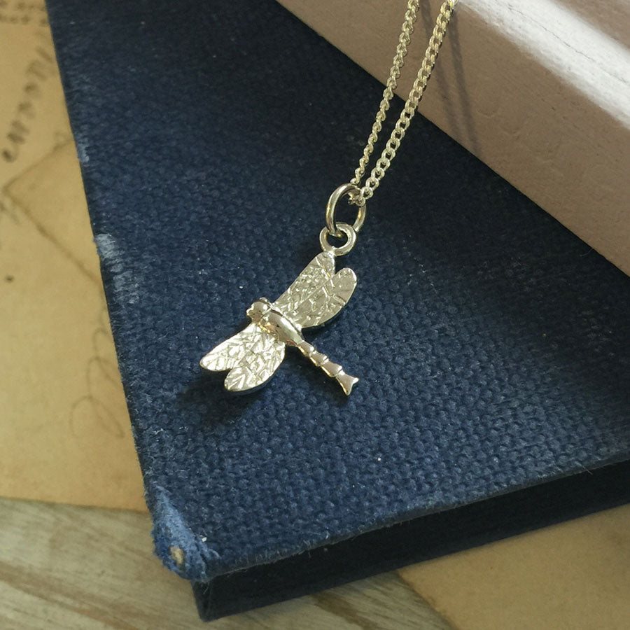 Solid gold dragonfly necklace handcrafted in London, a meaningful talisman of transformation and joy.