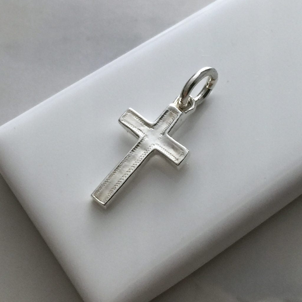 Bianca Jones handmade solid gold cross charm with intricate detailing along the edge, available in white, rose, and yellow gold